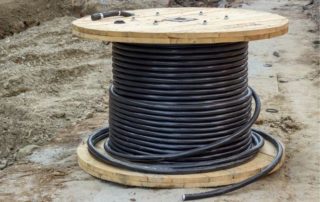 cable used for underground utilities is wrapped around a wooden post