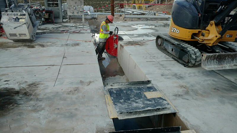 a man is cutting concrete with saw